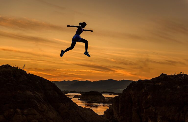 woman jumping over hills